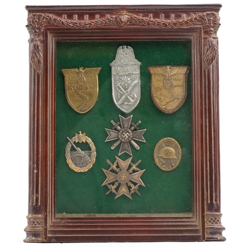 2547 - Seven German military interest cap badges, framed and glazed, 31cm x 25cm.