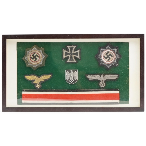 2546 - Six German military interest cap badges, framed and glazed.