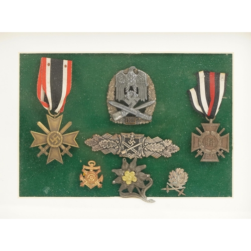 2544 - Five German military interest cap badges and two medals, framed and glazed.