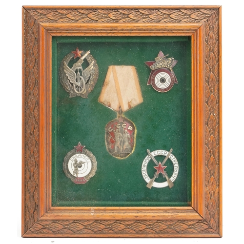 2484 - Four Russian military interest cap badges and medal, framed and glazed.