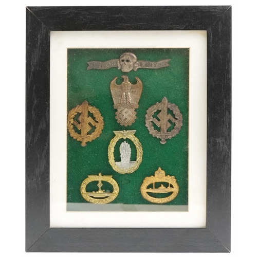 2548 - Seven German military interest cap badges, framed and glazed.