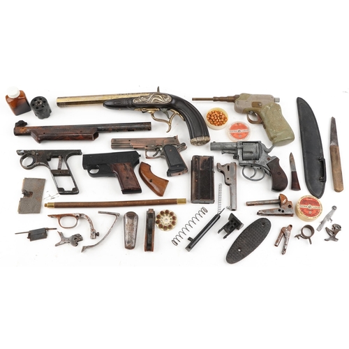 2606A - A collection of military interest gun parts, starting pistol and a decorative percussion pistol.