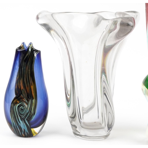 1411 - A group of four mid 20th century art glass pieces to include a clear glass vase, a red and green vas... 