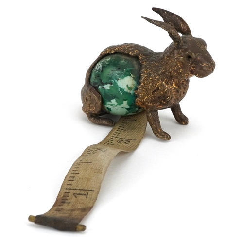 9 - A novelty antique tape measure in the form a rabbit with tail winder, 5.5cm in length.