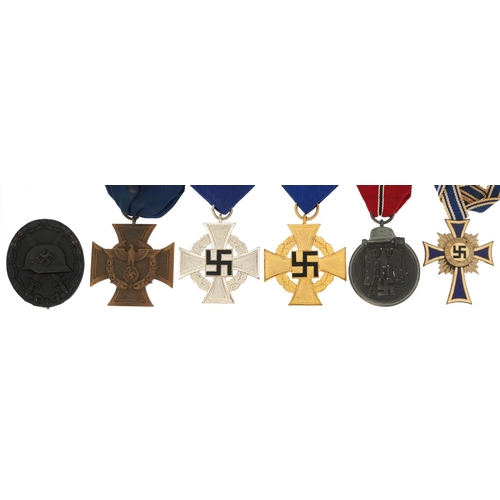 2558 - Five German military interest medals and a cap badge including a Mother's Cross.