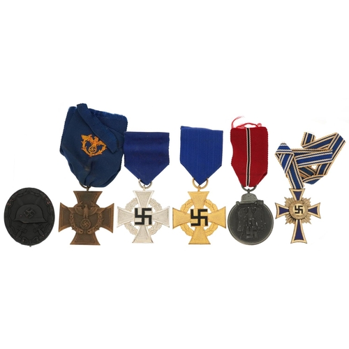 2558 - Five German military interest medals and a cap badge including a Mother's Cross.