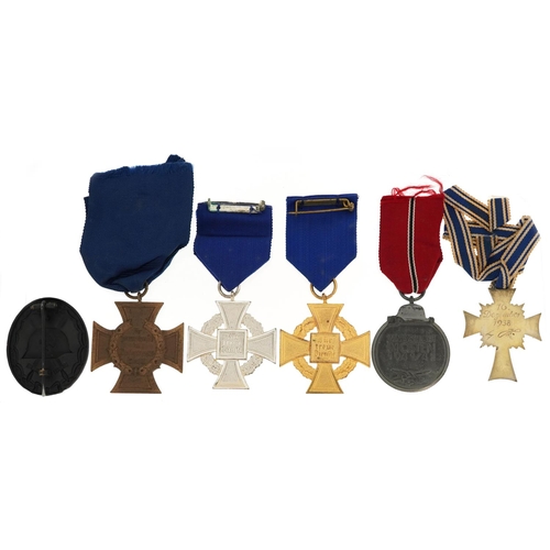 2558 - Five German military interest medals and a cap badge including a Mother's Cross.