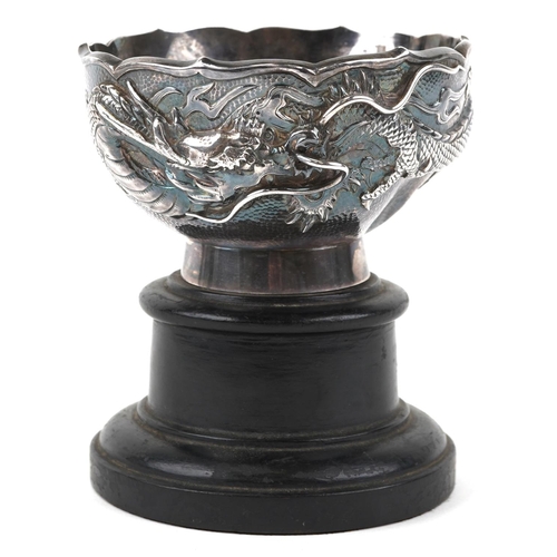  A Chinese export silver dragon bowl, late 19th/early 20th century, bearing mark to base, raised on a... 