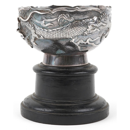  A Chinese export silver dragon bowl, late 19th/early 20th century, bearing mark to base, raised on a... 