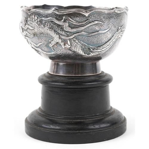  A Chinese export silver dragon bowl, late 19th/early 20th century, bearing mark to base, raised on a... 