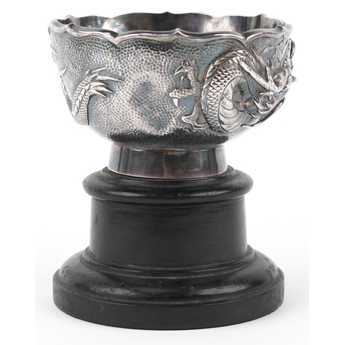  A Chinese export silver dragon bowl, late 19th/early 20th century, bearing mark to base, raised on a... 