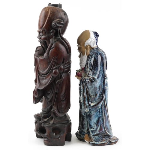 1516 - A large Chinese carved wood figure of an elder with staff and fruit together with a Mud Man example,... 