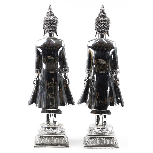 1459 - A large pair of silvered figures of standing Tibetan Buddha, 65cm high.