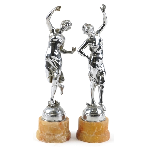 69 - A pair of Art Deco chromium plated figures of dancing girls, each raised on a circular marble plinth... 