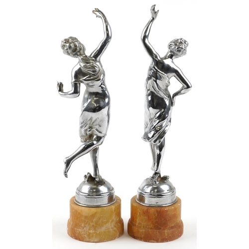 69 - A pair of Art Deco chromium plated figures of dancing girls, each raised on a circular marble plinth... 