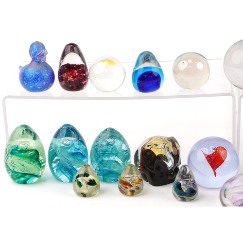 354 - A collection of colourful glass paperweights including Caithness, the largest 9cm in diameter.