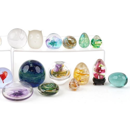 354 - A collection of colourful glass paperweights including Caithness, the largest 9cm in diameter.