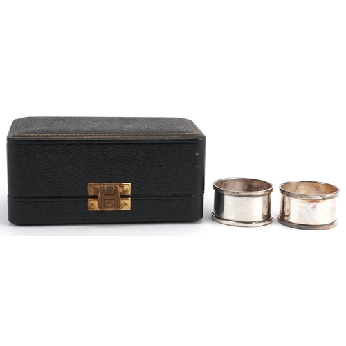 462 - C T Burrows & Sons, a pair of George V silver napkin rings housed in a velvet and silk lined fitted ... 