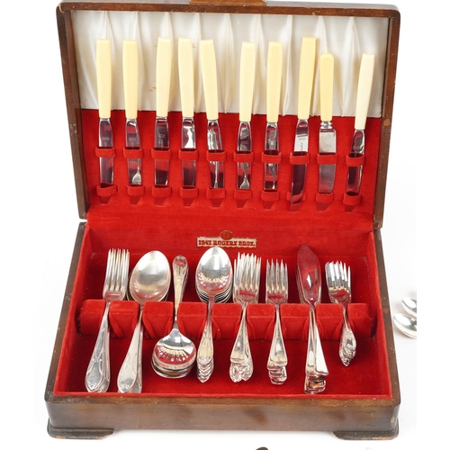 1166 - An Art Deco mahogany canteen of mostly Sheffield silver plated cutlery, the knives with ivorine hand... 