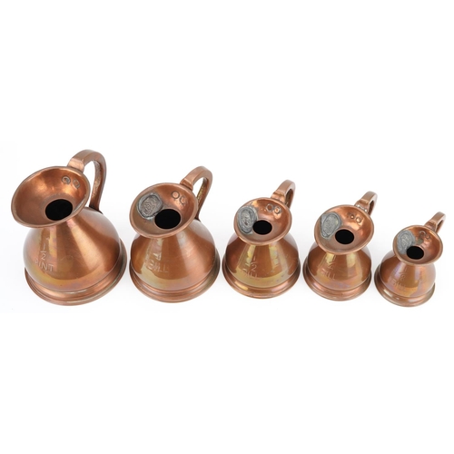 130 - A graduated set of five late 19th century copper measuring jugs, largest H-13cm