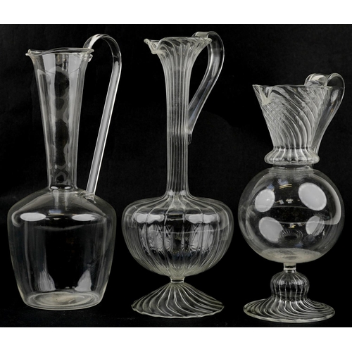 38 - Three early 20th century, possibly Italian, export clear glass ewers, the largest 32cm high.