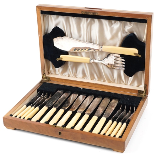 1164 - An Art Deco plated set of fish knives and forks, within a walnut case, W-35cm.