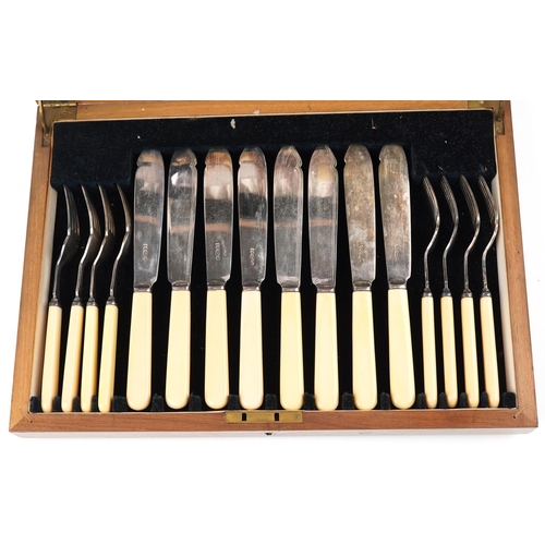 1164 - An Art Deco plated set of fish knives and forks, within a walnut case, W-35cm.