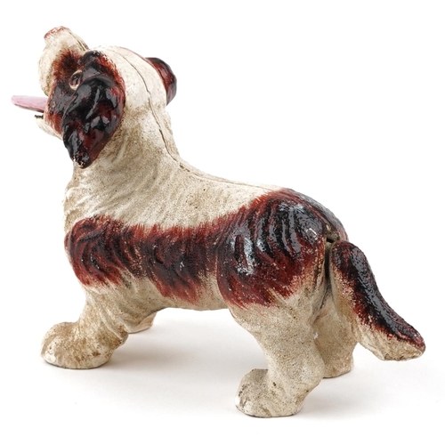 1595 - A novelty cast iron puppy with moving tail and tongue, 20cm in length.