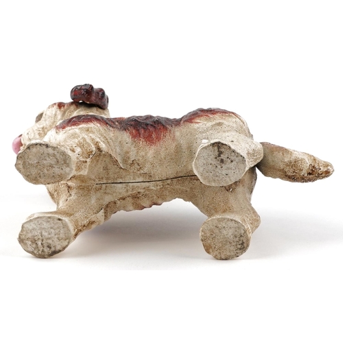 1595 - A novelty cast iron puppy with moving tail and tongue, 20cm in length.