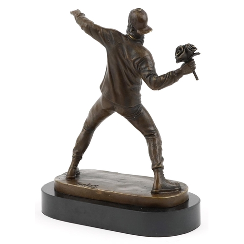 188 - A bronze figure of The Flower Thrower raised on a black slate/marble stand, 26cm high.