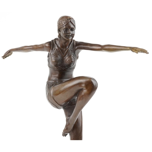 187 - A patinated bronze study of an Art Deco female dancer raised on a marble column base, 56cm high.