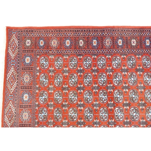 1093 - An Afghan rug, late 20th century, the red field with five central columns of guls within a complemen... 