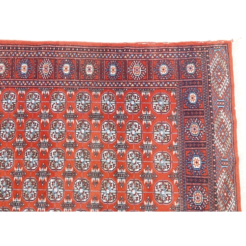 1093 - An Afghan rug, late 20th century, the red field with five central columns of guls within a complemen... 