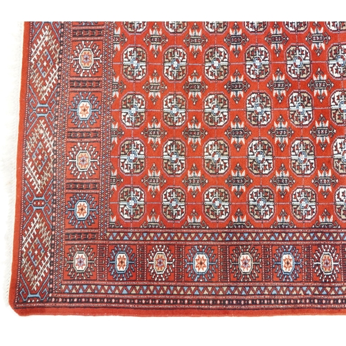 1093 - An Afghan rug, late 20th century, the red field with five central columns of guls within a complemen... 