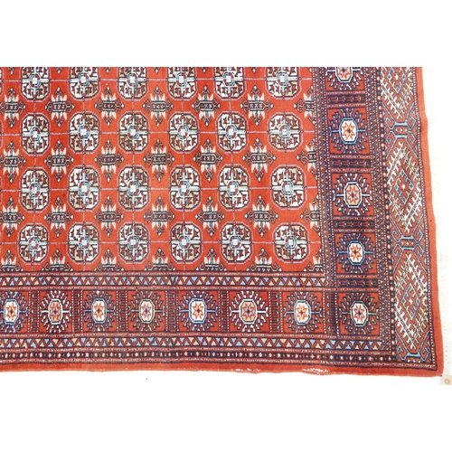 1093 - An Afghan rug, late 20th century, the red field with five central columns of guls within a complemen... 