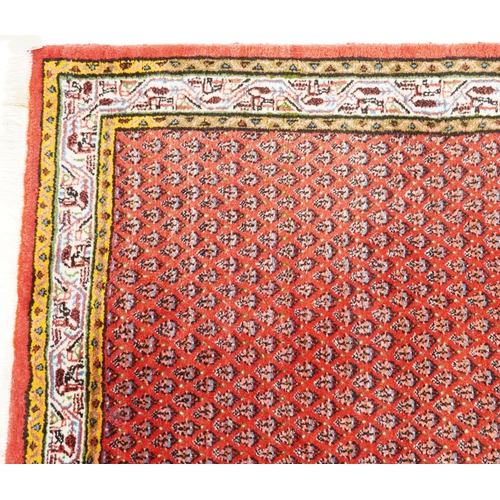 1094 - A Hamadan rug, late 20th century, the red field with an allover flower head design within a compleme... 