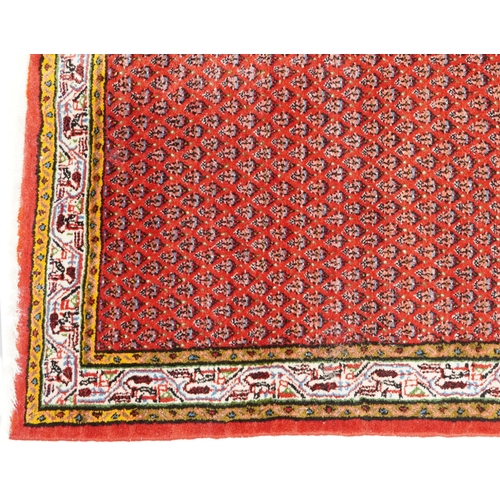 1094 - A Hamadan rug, late 20th century, the red field with an allover flower head design within a compleme... 