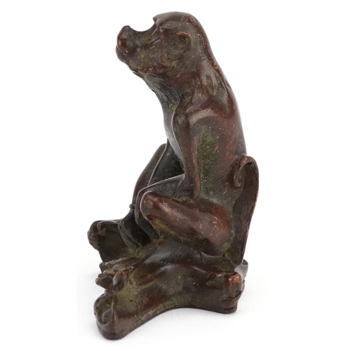 115 - A Japanese patinated bronze okimono of a seated monkey, character marks to the base, 6cm high.