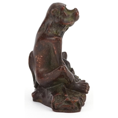 115 - A Japanese patinated bronze okimono of a seated monkey, character marks to the base, 6cm high.