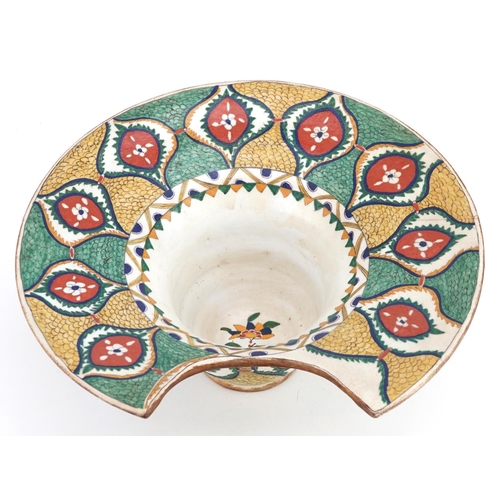 119 - A Turkish Ottoman Kütahya barber's bowl hand painted with stylized flowers and foliage, 31.5cm wide.