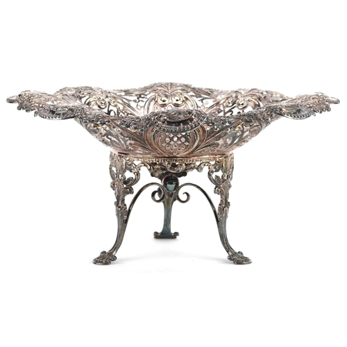 389 - An Edwardian silver centrepiece bowl, raised on three feet, profusely embossed and pierced with flow... 