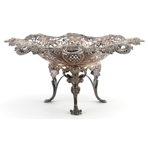 389 - An Edwardian silver centrepiece bowl, raised on three feet, profusely embossed and pierced with flow... 