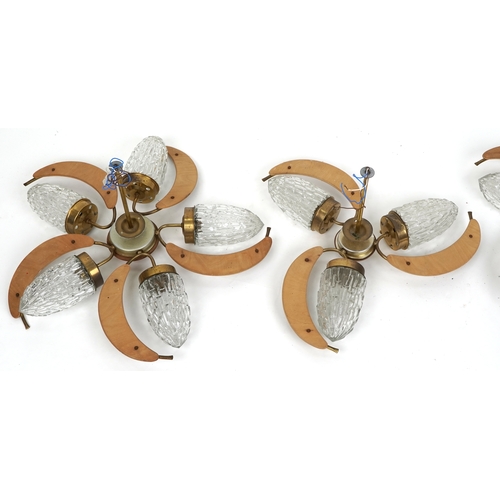 1116 - A set of three mid 20th teak and moulded glass ceiling lights, two with five lights the other three.