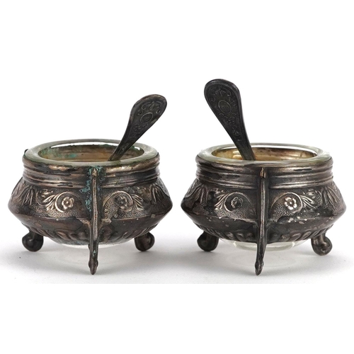 478 - A pair of Russian Ommet white metal open salts with glass liners and spoons, 5.5cm in diameter.