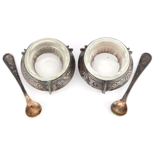 478 - A pair of Russian Ommet white metal open salts with glass liners and spoons, 5.5cm in diameter.