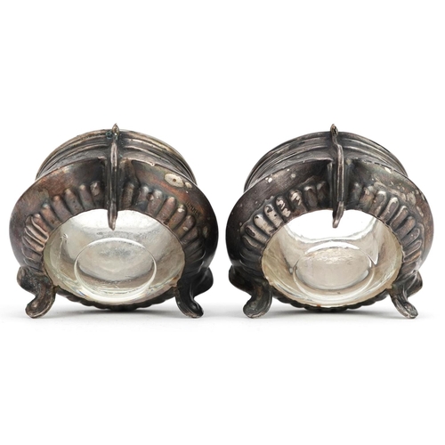 478 - A pair of Russian Ommet white metal open salts with glass liners and spoons, 5.5cm in diameter.