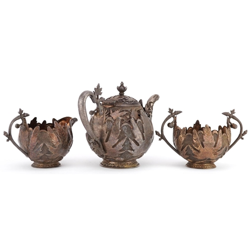 437 - A Middle Eastern white metal naturalistic three piece tea set profusely embossed with foliage and fr... 