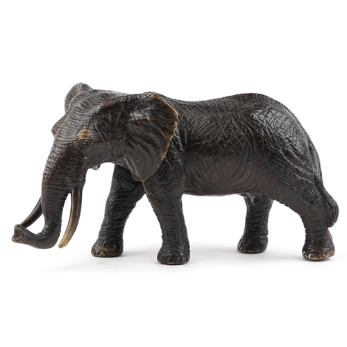 1567 - A Japanese patinated bronze okimono of a bull elephant, 31cm in length.