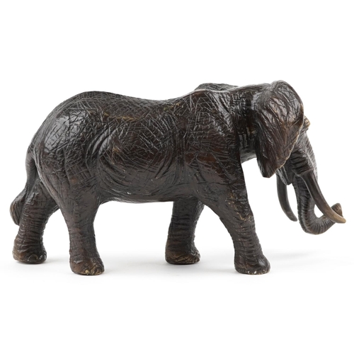 1567 - A Japanese patinated bronze okimono of a bull elephant, 31cm in length.