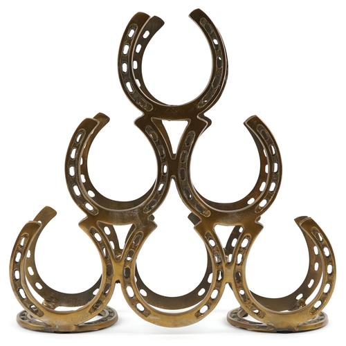 1563 - A bronzed six place wine rack in the form of horseshoes, 40cm high.